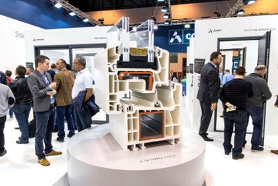 Stand with visitors and large model.