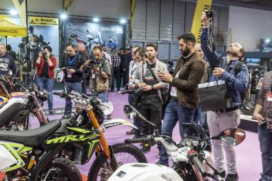 Momento de la presentación de un modelo de moto novedad en un stand rodeado de periodistas y fotógrafos