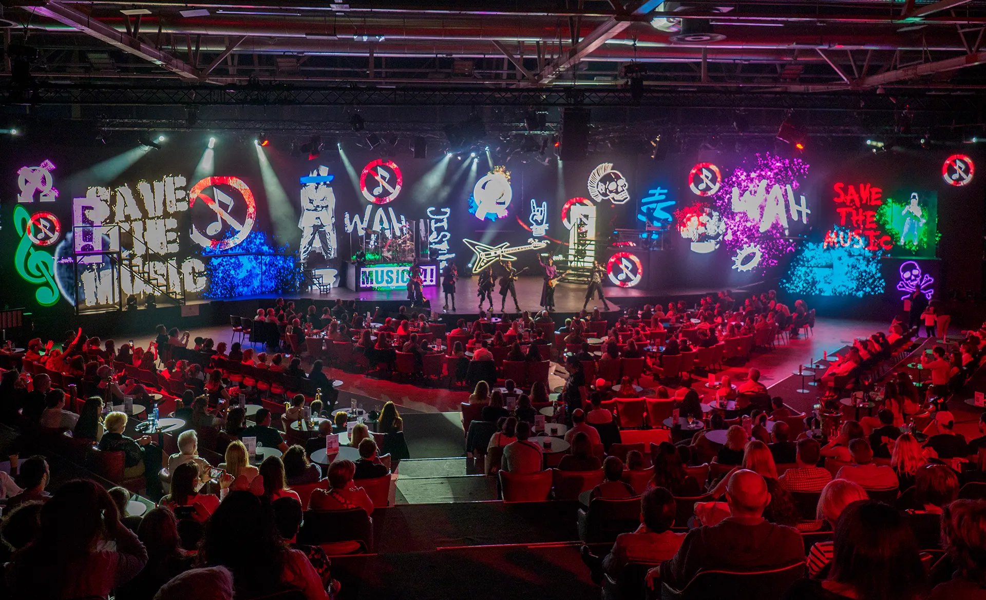 WAH stage with neon lights and performers and audiences